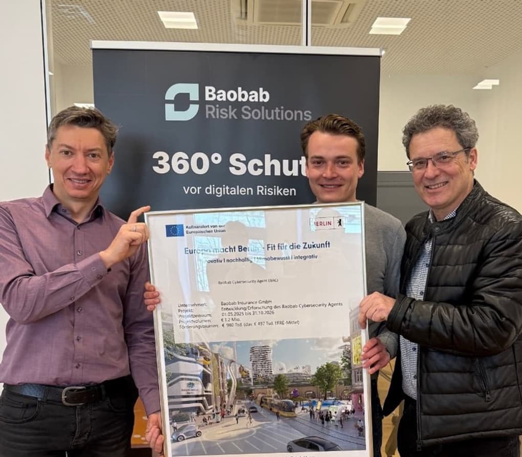 Drei Personen halten gemeinsam einen Fördernachweis des Baobab Cybersecurity Agent (BCA) vor einem Baobab Risk Solutions Roll-up
