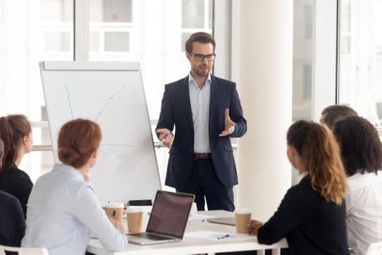 Mann steht vor einem Publikum und macht coaching für Fördergeld